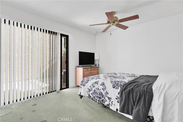 carpeted bedroom with access to outside, a ceiling fan, and a textured ceiling