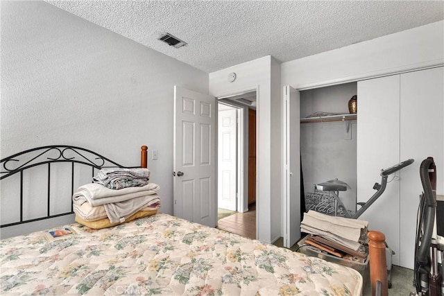 bedroom featuring visible vents, a textured ceiling, and a closet