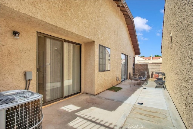 exterior space featuring central AC, fence, a patio area, and stucco siding