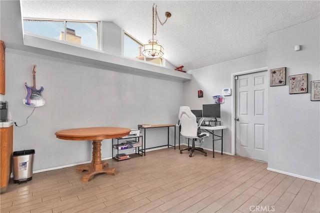 office with a textured ceiling, baseboards, wood finished floors, and lofted ceiling