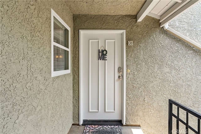 property entrance featuring stucco siding