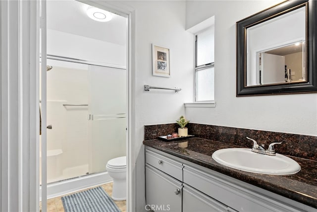 full bath featuring vanity, toilet, and a shower stall