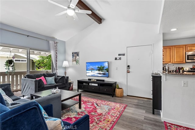 living area with ceiling fan, wood finished floors, baseboards, beamed ceiling, and recessed lighting
