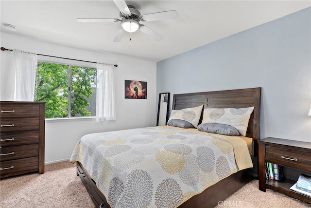 bedroom featuring a ceiling fan, baseboards, and light carpet