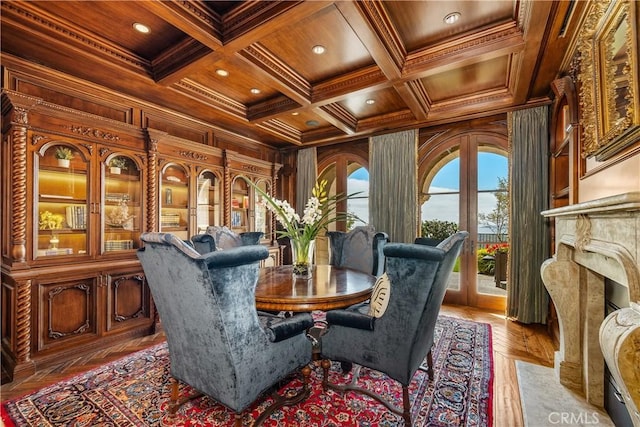 dining area with wooden walls, ornamental molding, wood ceiling, and coffered ceiling