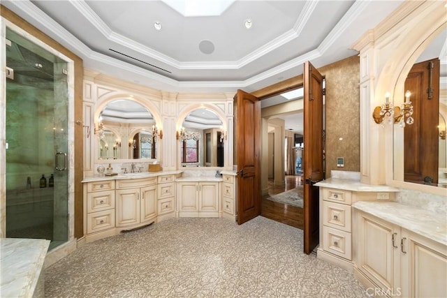 full bathroom featuring a tray ceiling, vanity, ornamental molding, and a stall shower