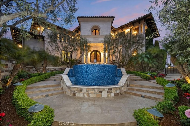 view of front of home featuring stucco siding and stairway