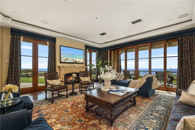 living area featuring visible vents, plenty of natural light, and wood finished floors