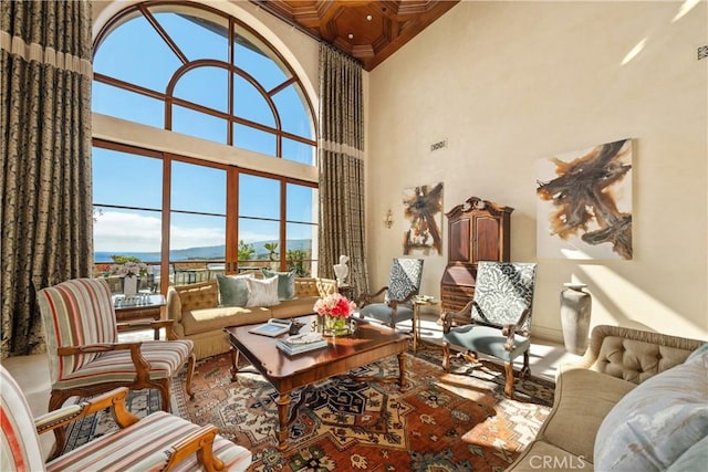 living room featuring visible vents, ornamental molding, and a towering ceiling