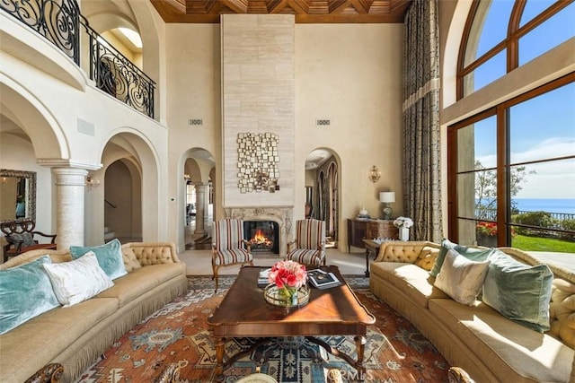 interior space with decorative columns, a tile fireplace, and a towering ceiling