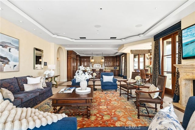 living area with an inviting chandelier, arched walkways, and a high end fireplace