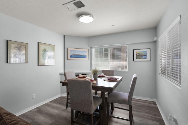 dining space featuring wood finished floors and baseboards