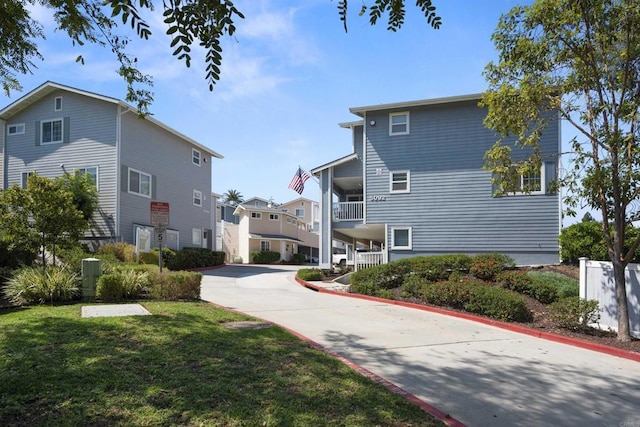 view of side of property with a yard, a residential view, and driveway