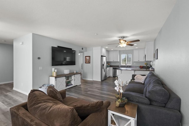 living room with dark wood-style floors, ceiling fan, baseboards, and recessed lighting