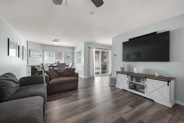 living area with wood finished floors, a ceiling fan, and baseboards
