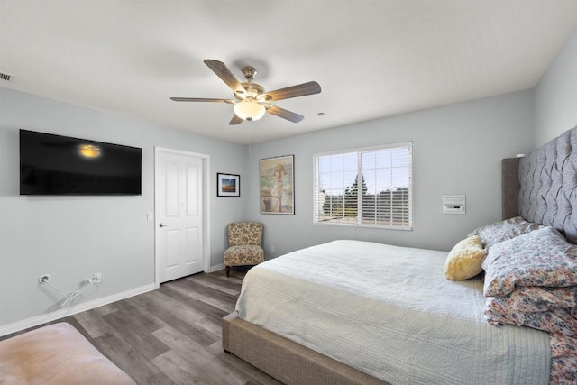 bedroom with wood finished floors, baseboards, and a ceiling fan