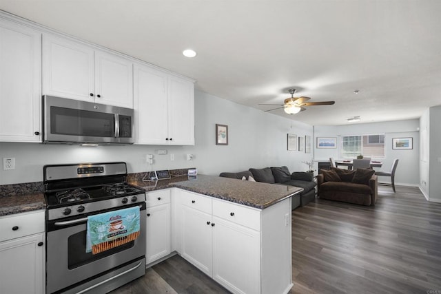 kitchen with appliances with stainless steel finishes, a peninsula, ceiling fan, white cabinets, and open floor plan