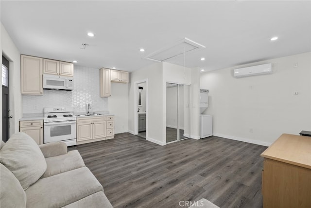 kitchen featuring an AC wall unit, open floor plan, white appliances, and tasteful backsplash