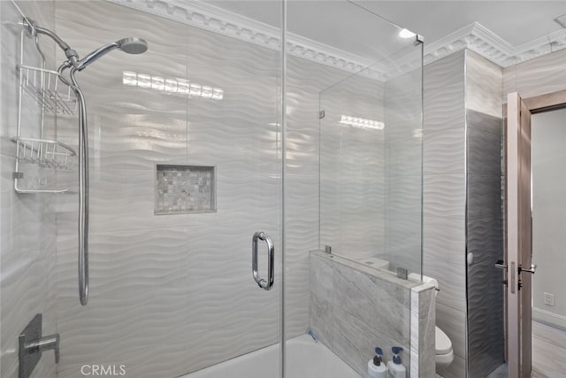 bathroom featuring crown molding, toilet, and shower / bath combination with glass door