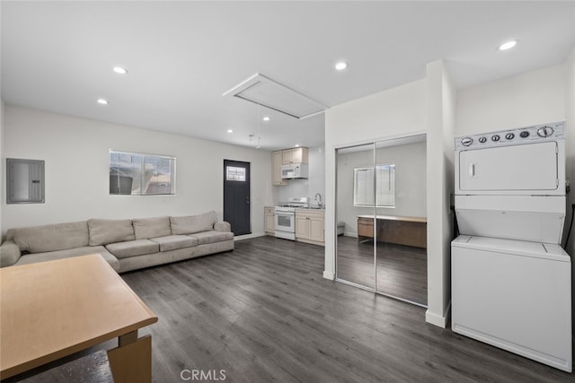 living area featuring stacked washer and dryer, recessed lighting, dark wood-style floors, and attic access