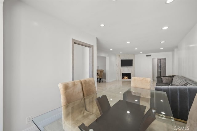 dining area with baseboards, recessed lighting, and a fireplace
