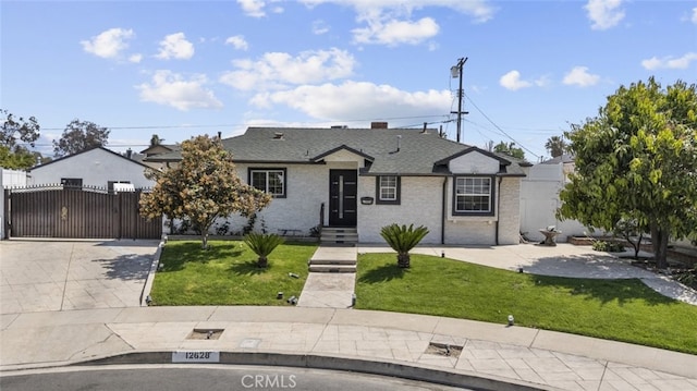 bungalow-style home with fence, a gate, driveway, and a front yard