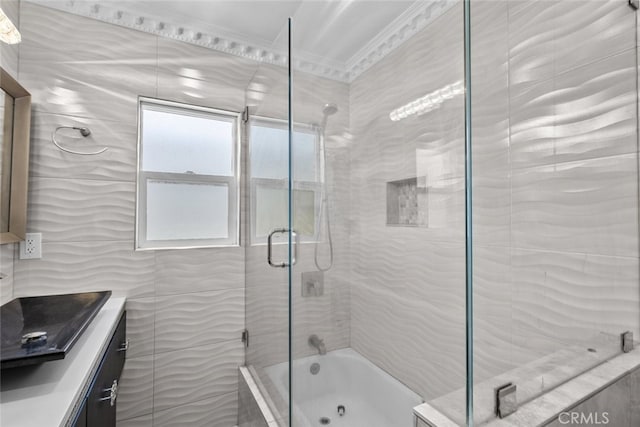 bathroom featuring crown molding, tiled shower / bath, tile walls, and vanity