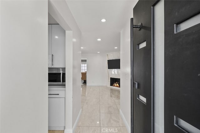 hall with recessed lighting, baseboards, and light tile patterned flooring