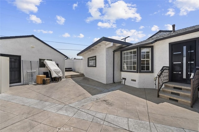 back of property featuring fence, a patio, and stucco siding