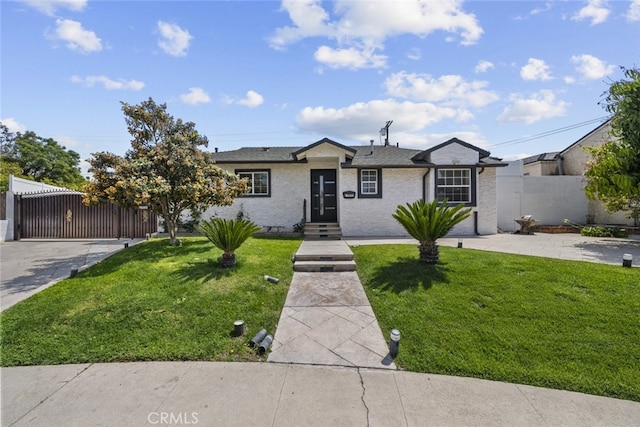 ranch-style home with fence, a gate, and a front lawn