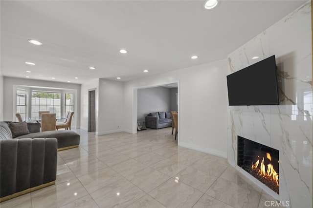 living room with recessed lighting, baseboards, a premium fireplace, and marble finish floor
