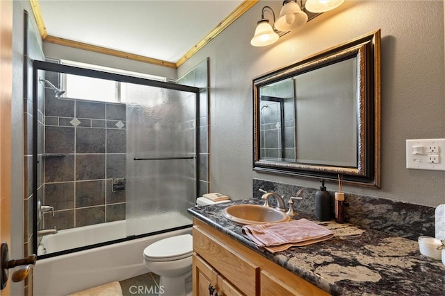 full bath with toilet, vanity, crown molding, a textured wall, and bath / shower combo with glass door