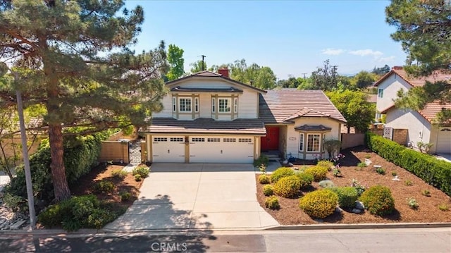 traditional-style home with an attached garage, fence, driveway, and a chimney