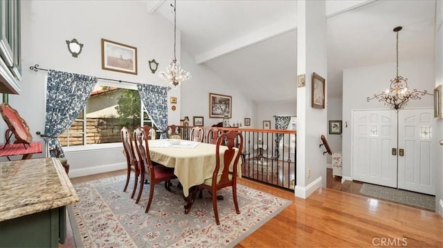 dining room with high vaulted ceiling, beamed ceiling, light wood-style flooring, and a notable chandelier