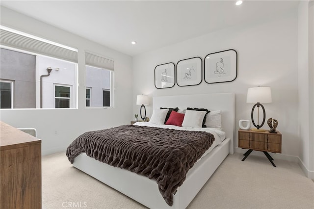 bedroom with light colored carpet, recessed lighting, and baseboards