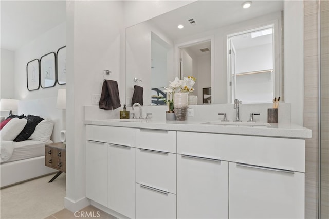 ensuite bathroom featuring double vanity, recessed lighting, a sink, and ensuite bathroom