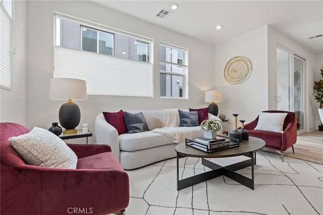 living room with visible vents, wood finished floors, and a healthy amount of sunlight