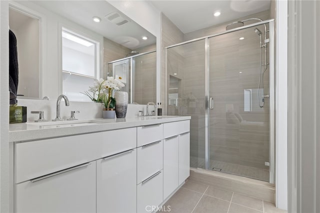 full bathroom with tile patterned floors, visible vents, a sink, and a stall shower