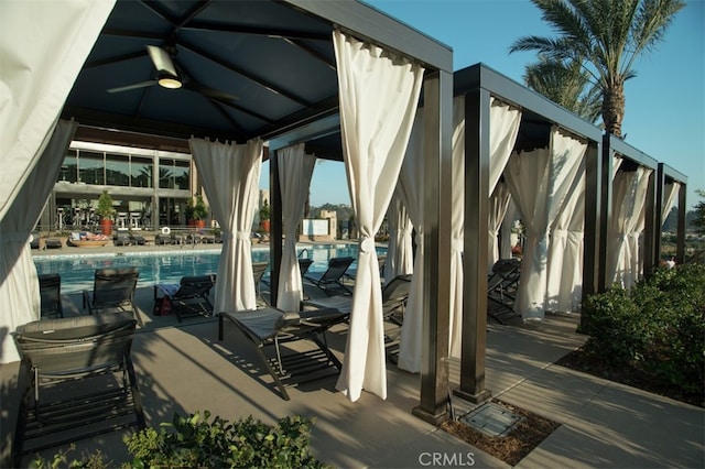 view of patio / terrace with a community pool, a gazebo, and ceiling fan