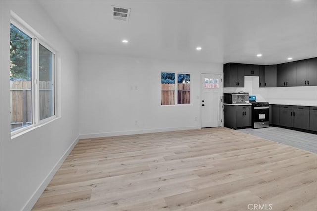 kitchen with visible vents, baseboards, gas stove, and light wood-type flooring