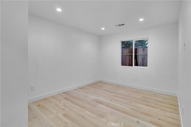 spare room with baseboards, recessed lighting, wood finished floors, and visible vents