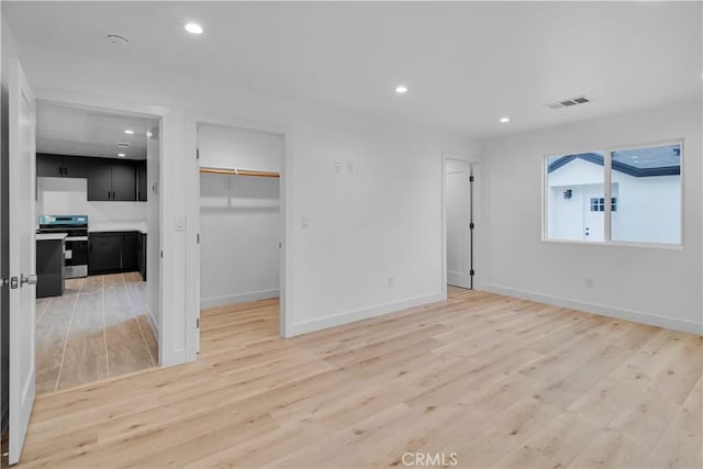 unfurnished living room with recessed lighting, baseboards, visible vents, and light wood-style floors