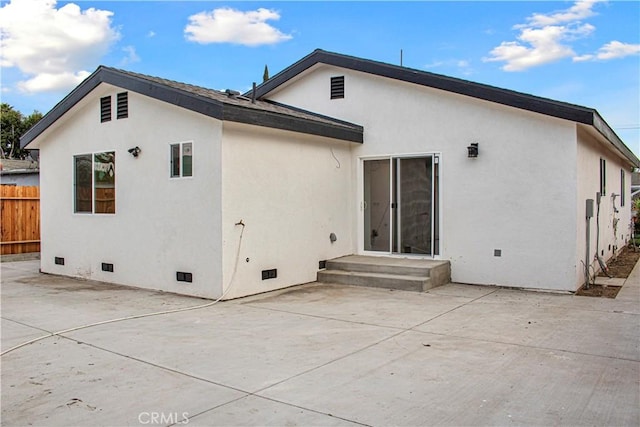 back of house featuring stucco siding, a patio area, fence, and crawl space