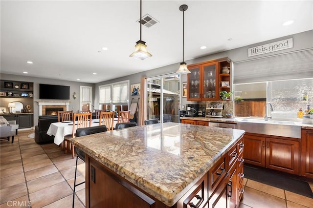 9 Woodlake Dr, Buena Park, CA 90621 - kitchen with a warm lit fireplace, a breakfast bar, a sink, recessed lighting, and light tile patterned floors