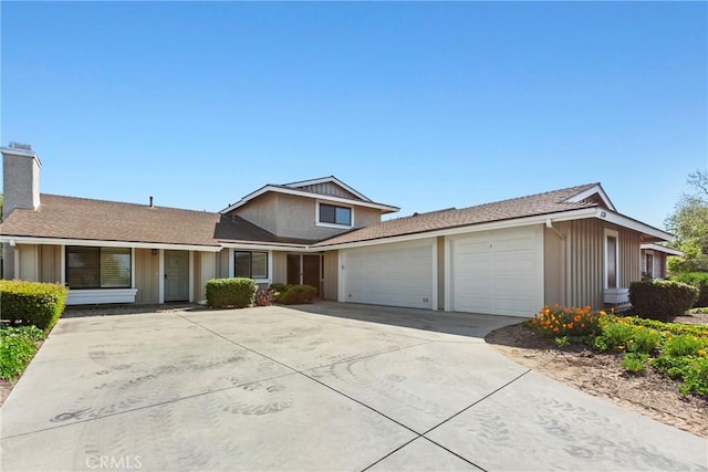 1126 E Foster Rd Unit B, Santa Maria, CA 93455 - traditional home featuring a garage, board and batten siding, a chimney, and driveway