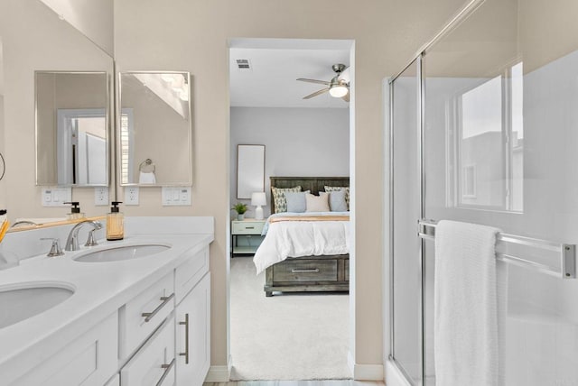 bathroom with double vanity, ensuite bathroom, ceiling fan, a shower stall, and a sink