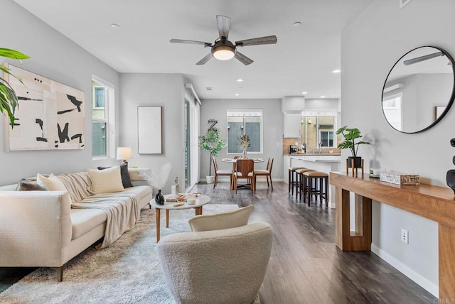 living area with a ceiling fan, baseboards, recessed lighting, and wood finished floors