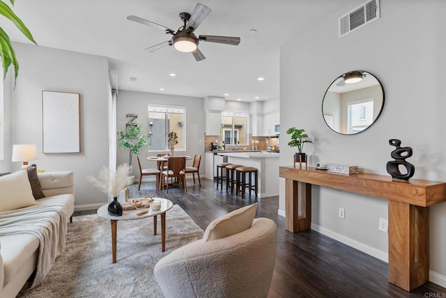 living room with ceiling fan, recessed lighting, baseboards, dark wood-type flooring, and visible vents
