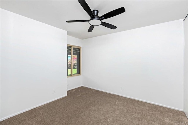 carpeted spare room with baseboards and a ceiling fan