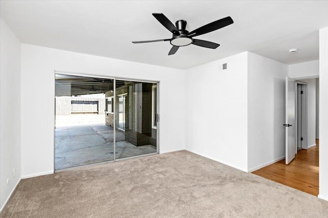 carpeted empty room with ceiling fan, visible vents, and baseboards